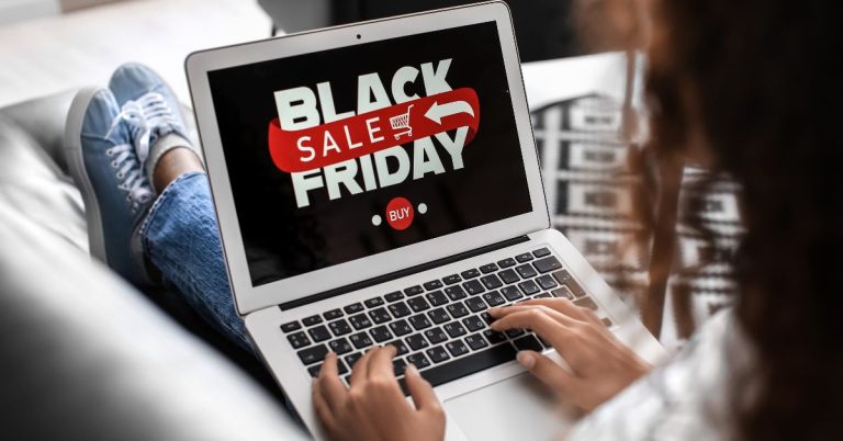 Woman sitting with a laptop shopping Black Friday Sales
